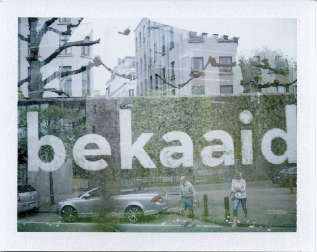 Antwerp by association, double exposed polaroid. Combination of a man with crutches and the word misfortune.